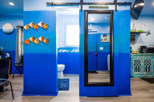bagno blu con specchio e servizi igienici di Whimsical Tiny House, Cape Charles Virginia a Cape Charles