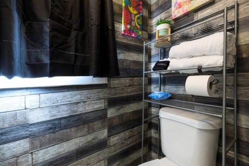a bathroom with wooden walls and a toilet at Red House Tiny Home in Cape Charles