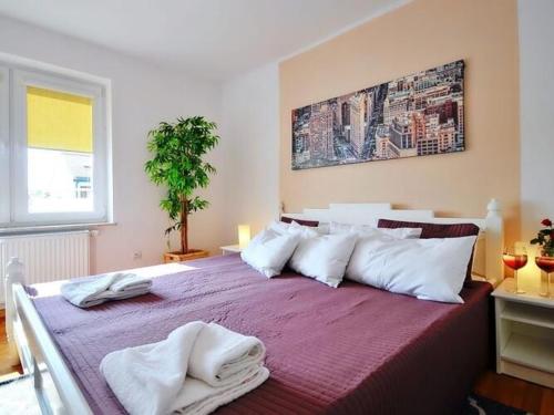 a bedroom with a large bed with towels on it at Comfortable apartment with a balcony, very close to the sea, Ustronie Morskie in Ustronie Morskie