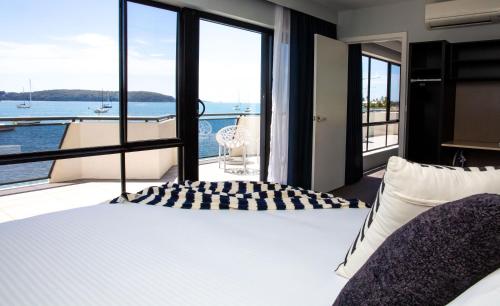 Schlafzimmer mit einem Bett und Blick auf das Wasser in der Unterkunft The Esplanade Motel in Batemans Bay