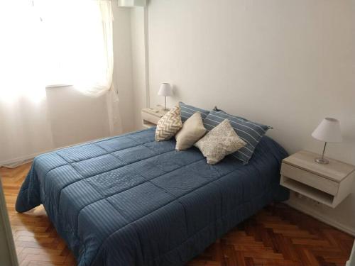 Un dormitorio con una cama azul con almohadas. en Departamento en Recoleta en Buenos Aires