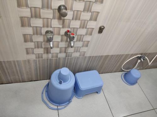 a bathroom with two blue toilets in a room at Hotel Yogiraj in Shirdi
