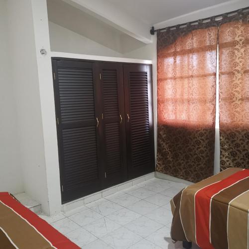 - une chambre avec des portes de placard noir et un lit dans l'établissement Casa marthita, à Cozumel