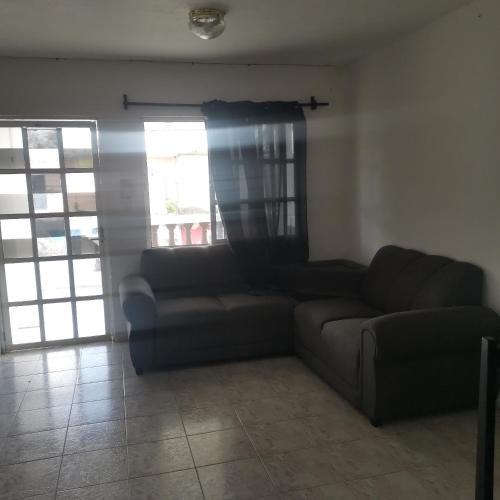 sala de estar con sofá y ventana en Casa marthita, en Cozumel