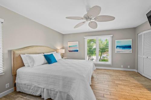 a bedroom with a bed and a ceiling fan at La Buena Vida - Bright Beachy Canal Front Steps to Beach PoolSpa Dock Beach Gear Dogs OK in Anna Maria