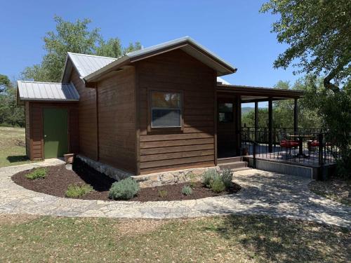 a small cabin with a porch and a patio at Hill Country Hideout in Pipe Creek
