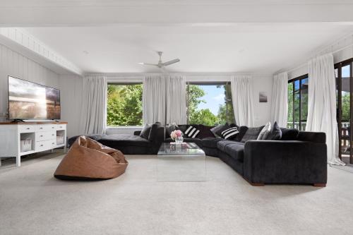 a living room with a black couch and a tv at "Uralla" Lovely house with pool in Bathurst