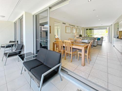 a dining room and living room with a table and chairs at Serenity in Picnic Bay