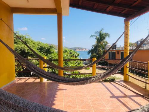 a hammock on a balcony with a view of the ocean at Habitaciones Chalo in Garita