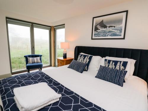 a bedroom with a large bed with blue and white pillows at Ysgoldy Brynwyre in Llanrhystyd