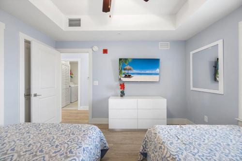 a bedroom with two beds and a white dresser at Brand New Calypso Resort Tower 3! Sleeps 9! Free Beach Chair Service! by Dolce Vita Getaways PCB in Panama City Beach