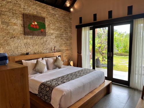 a bedroom with a bed and a large window at The Lava Bali Villa and Hot Spring in Kintamani