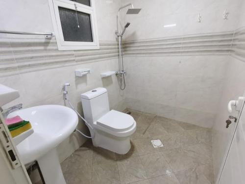 استوديو مفروش في عجمان: حمام ابيض مع مرحاض ومغسلة