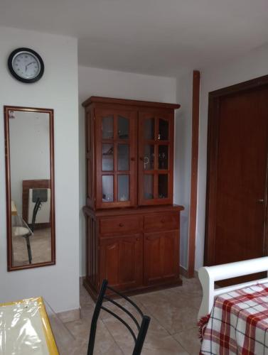 a room with a wooden cabinet and a mirror at FREEDOM Joa in Río Gallegos