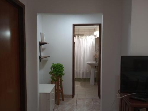 a hallway with a bathroom with a sink and a television at FREEDOM Joa in Río Gallegos