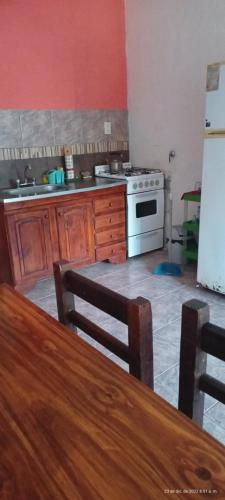 a kitchen with a stove and a table and a refrigerator at Apartamento económico in Villa Gesell