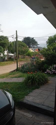 un coche aparcado junto a un jardín con flores en Apartamento económico en Villa Gesell