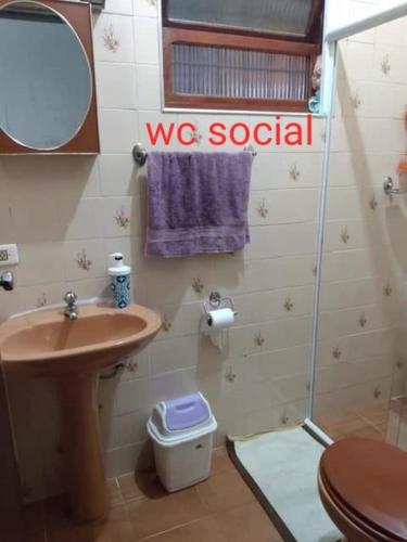a bathroom with a sink and a toilet and a mirror at Casa Próximo Centro Itanhaém in Itanhaém