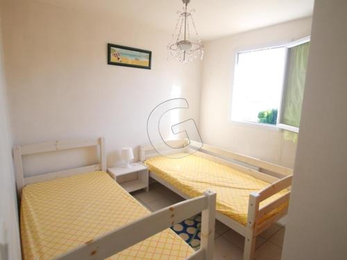 une chambre avec deux lits superposés et une fenêtre dans l'établissement Charmante maison pour 4 personnes avec terrasse, à 1,8 km de la plage et proche des commodités - FR-1-357-76, à Saint-Vincent-sur-Jard