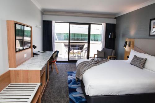 a hotel room with a bed and a desk at The Esplanade Motel in Batemans Bay