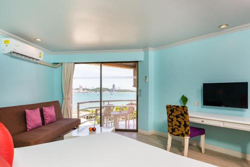 a room with a bed and a couch and a television at Bella Villa Metro in North Pattaya