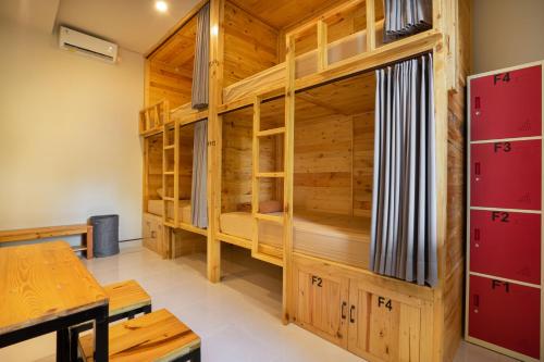 a room with bunk beds in a wooden cabin at K Hostel Seminyak in Seminyak