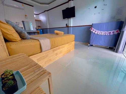 een kamer met een bed, een bank en een tv bij Baan Tipsukon in Ko Larn
