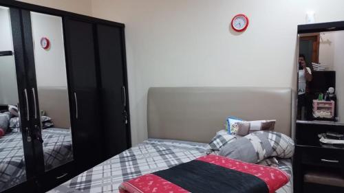 - une chambre avec un lit et un grand miroir dans l'établissement Second home, à Jakarta