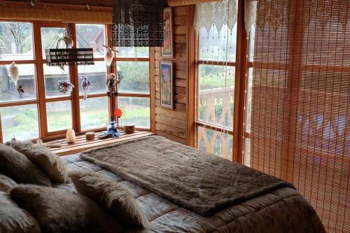 1 dormitorio con 1 cama grande en una habitación con ventanas en Fabulosa y mágica casa en Pingueral, en Tomé