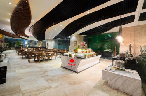 een restaurant met tafels en stoelen in een kamer bij Maple Hotel & Apartment in Nha Trang