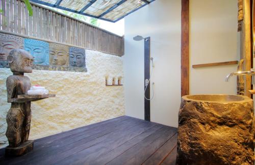 y baño con ducha y bañera de madera. en Villa Tatu by Optimum Bali Villas, en Canggu