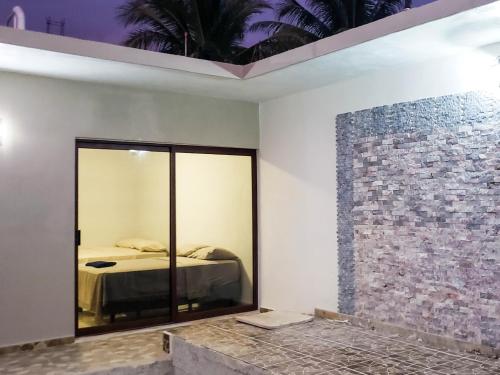 a room with a bed and a glass wall at Hotel Blue Turtle in Bacalar