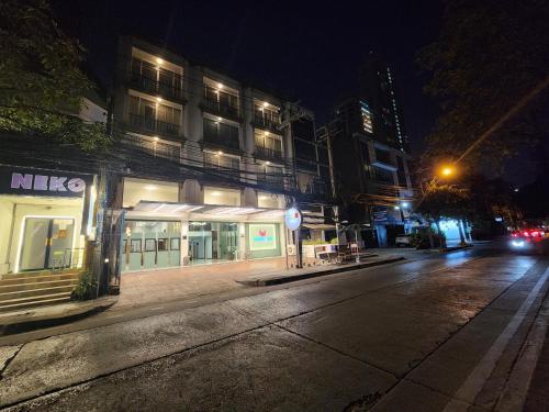 an empty city street at night with a building at August Residence in Bangkok