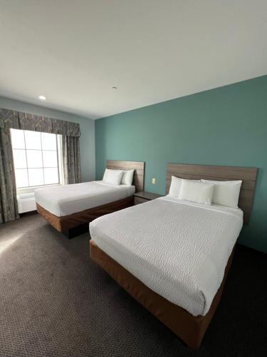a hotel room with two beds and a window at Americas Best Value Inn Sulphur in Sulphur