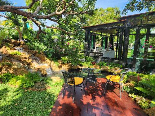 a patio with two chairs and a table and a pavilion at Baan Nern Khao Resort Pattaya in Ban Huai Yai