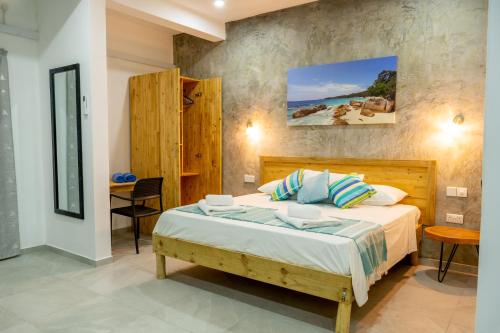 a bedroom with a bed and a table and a desk at VincVilla in Anse Possession