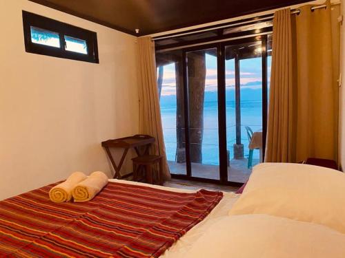 a bedroom with a bed with towels and a window at Villa Milagros Dive Inn Anilao in Bagalañgit