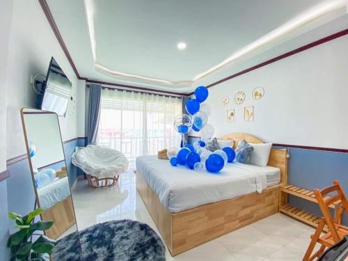 een slaapkamer met een bed met blauwe ballonnen erop bij Baan Tipsukon in Ko Larn