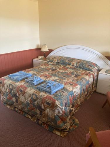 Una habitación de hotel con una cama con toallas azules. en Rangemore Estate, en Maclagan