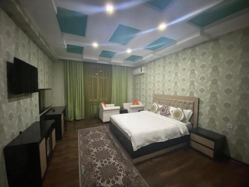 a bedroom with a bed and a blue ceiling at Sunrise Apartments in Dushanbe