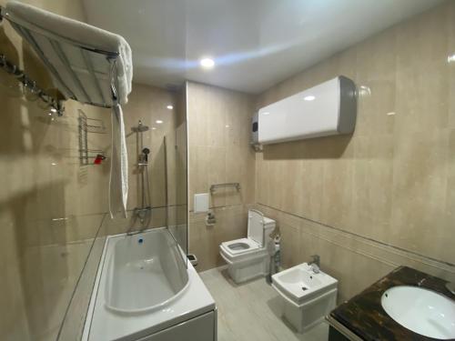 een badkamer met een wastafel en een toilet. bij Sunrise Apartments in Doesjanbe