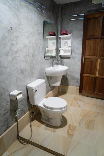 a bathroom with a toilet and a sink at Lanta Andaleaf Bungalow - SHA Extra Plus in Ko Lanta