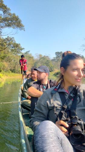 a group of people riding in a boat on a river at Hotel Tiger Tops Sauraha in Sauraha