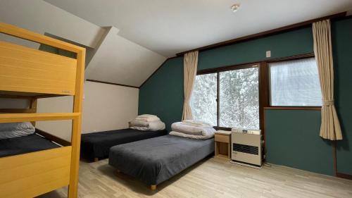 a bedroom with two bunk beds and a window at ZU-THONES HAKUBA ANNEX in Yotsuya