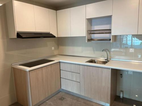 a kitchen with white cabinets and a sink at The Ooak Suites and Residence@ Kiara 163 in Kuala Lumpur