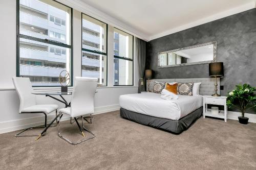 een slaapkamer met een bed en een tafel en stoelen bij Central Corporate Character in Auckland
