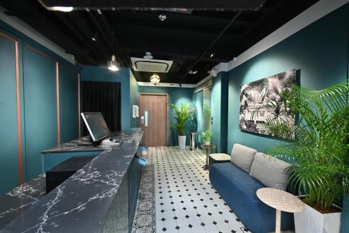 salon z niebieskimi ścianami i niebieską kanapą w obiekcie Dream Chaser Boutique Capsule Hotel w Singapurze