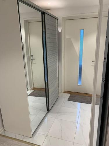 a hallway with a glass door and a mirror at Nice guesthouse with heat floor in Lilla Edet
