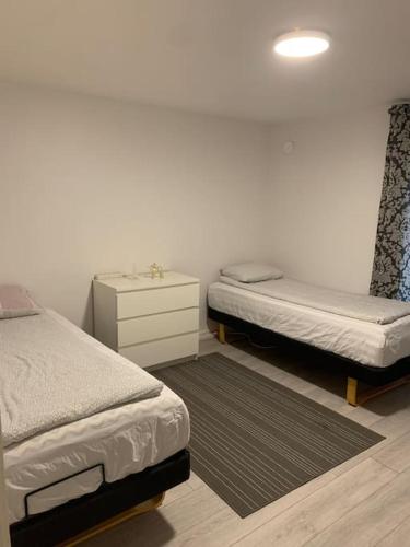 a bedroom with two twin beds and a night stand at Nice guesthouse with heat floor in Lilla Edet