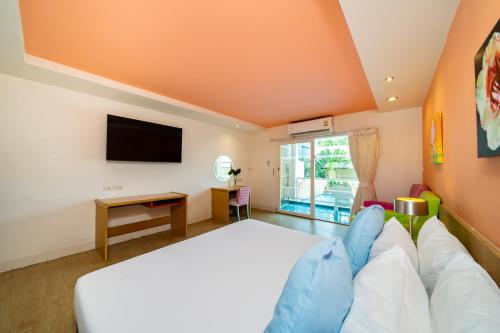 a bedroom with a large bed and a tv at Best Bella Pattaya in Pattaya North